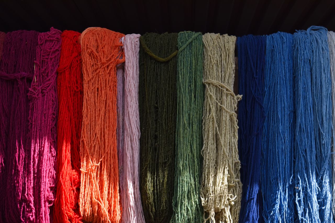 Hanks of dyed yarn hung in a full colour range.